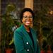 Zamakhanya Makhanya has afro hair, with black rimmed glasses, weating a green jacket smiling at the camera.