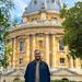 Ahmed Mohamed is wearing a black shirt , behind a traditional building smiling at the camera