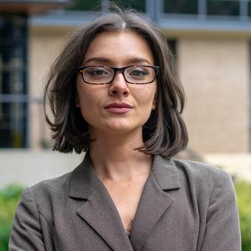 Aliyah Hurt has bobbed brown hair and is wearing a blazer and glasses.