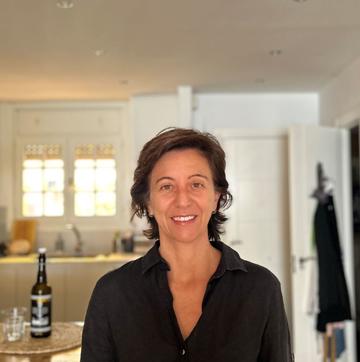 Margarita Leon has short black hair, wearing a black shirt and looking directly at the camera smiling.