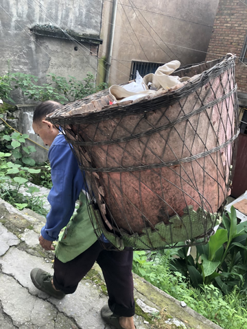 Chinese man carries basket on his back