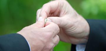 Men holding a wedding ring men holding a wedding ring