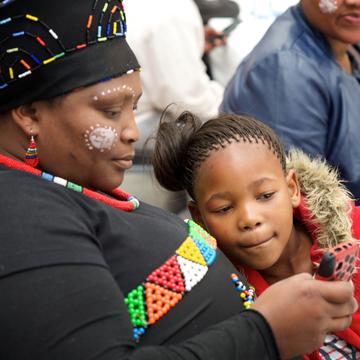 A person and a child looking at a mobile phone