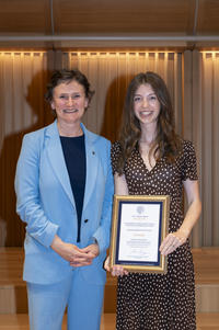 Two women standing next to each other, with one holding a certificate
