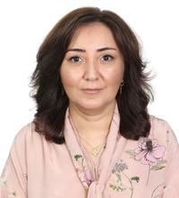 Bahija Aliyeva wears a peach blouse with a floral patters. She had shoulder-length dark brown hair and is on a plain white background.