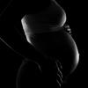 Black and white side profile silhouette of a pregnant woman