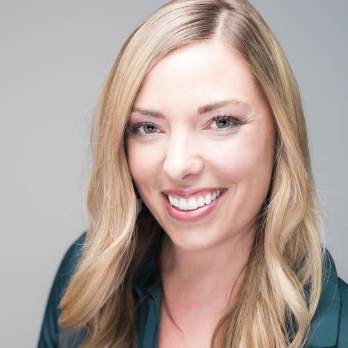 Kristen de Graaf has blonde shoulder-length hair and is wearing a dark jacket, smiling at the camera.