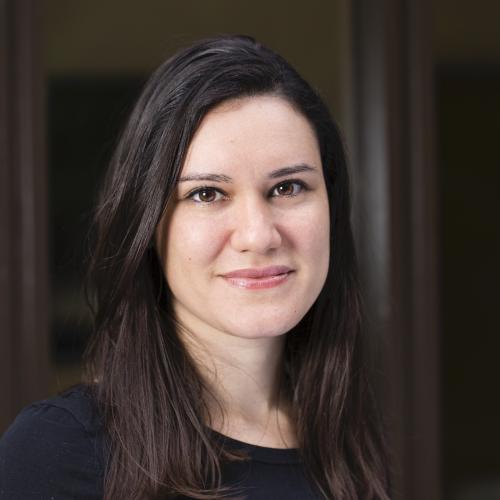 Dr Gabriela Pavarini has shoulder length dark hair, wearing a black top smiling gently at the camera.