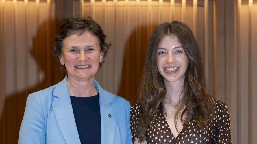 Two women standing next to each other, with one holding a certificate