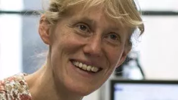 Tania is smiling at the camera, she has blonde hair and wearing a collared top with a floral pattern 