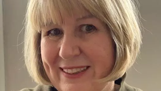 Rachel Yates has a blond bob hairstyle, smiling directly at the camera.