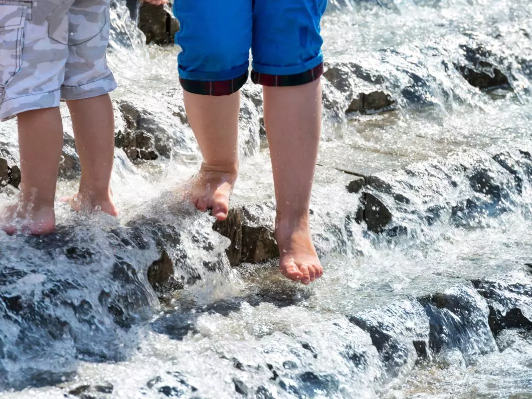 Water covered steps with two children's feet waking down them