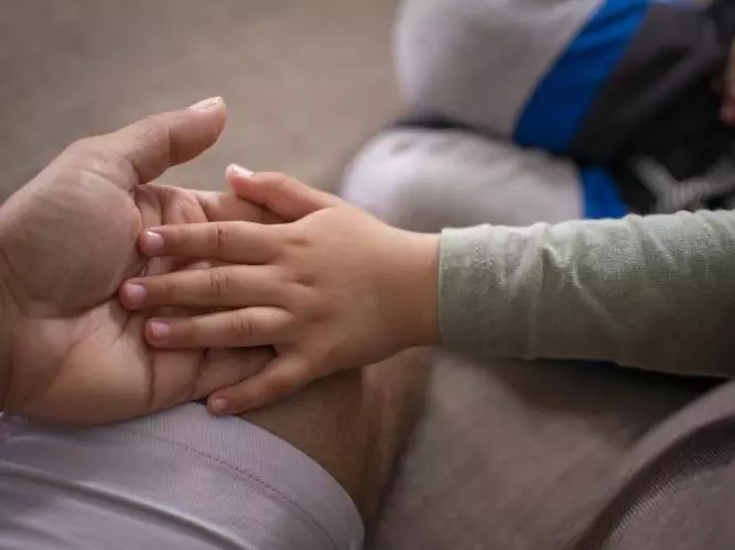 Child and adult holding hands