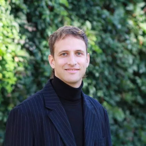 Lorenz Meister has short light brown hair and is wearing a dark turtleneck with navy blue pinstripe blazer. 