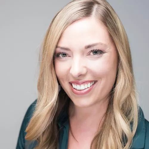 Kristen de Graaf has blonde shoulder-length hair and is wearing a dark jacket, smiling at the camera.