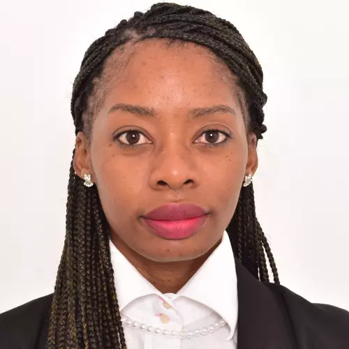 Looking directly at the camera, Katongo is wearing a white top, black jacket and shoulder-length black braids.