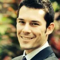 Matthew has short dark hair and smiling at the camera. He's wearing a smart checked white shirt with tie and jacket