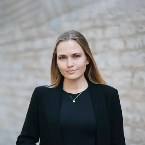 Moa Schafer has shoulder length blond hair, wearing a dark jacket looking at the camera. 