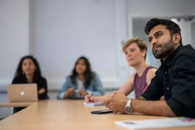 DSPI master's students around a table in a lecture room